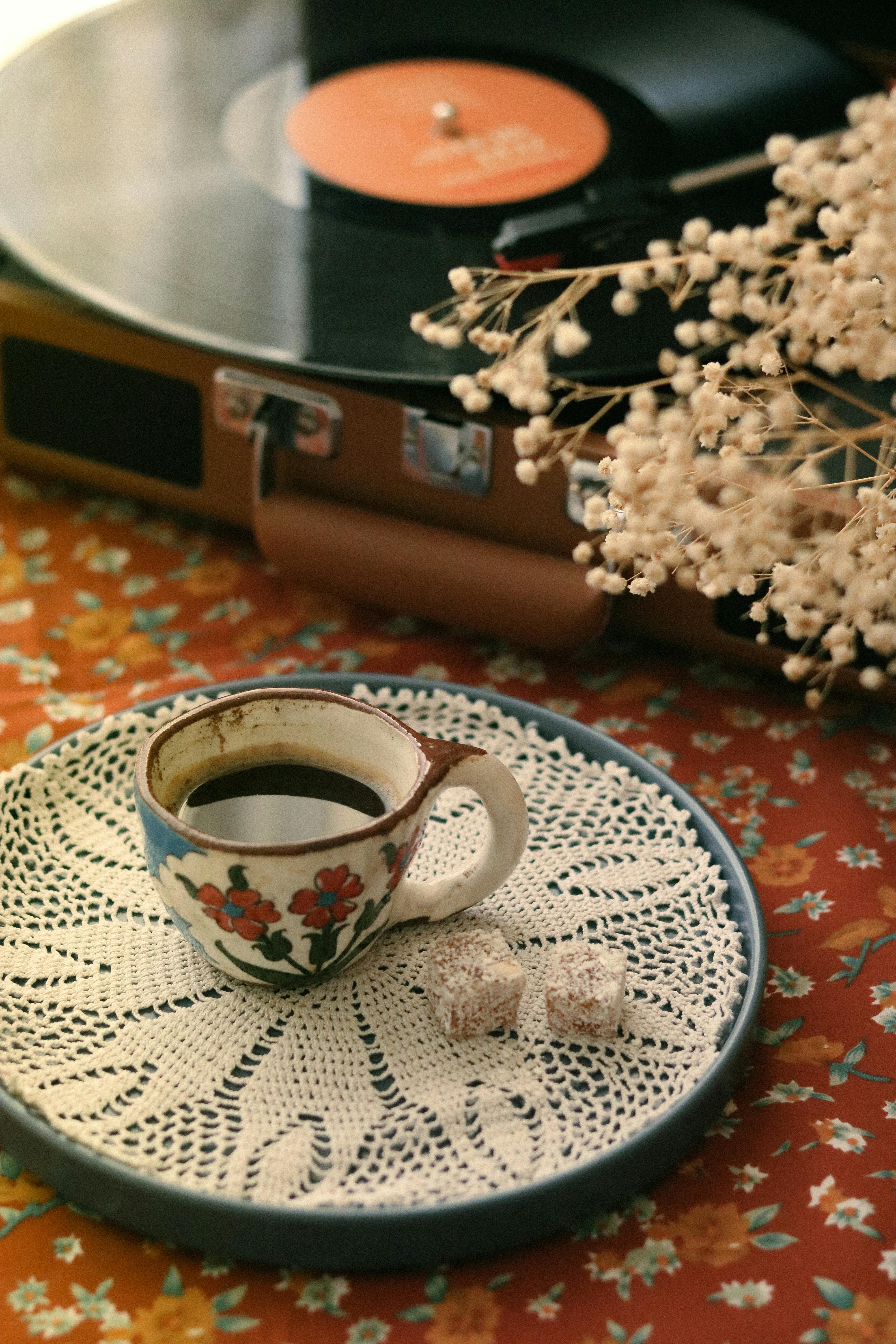 Uma xícara de café ao lado de uma vitrola