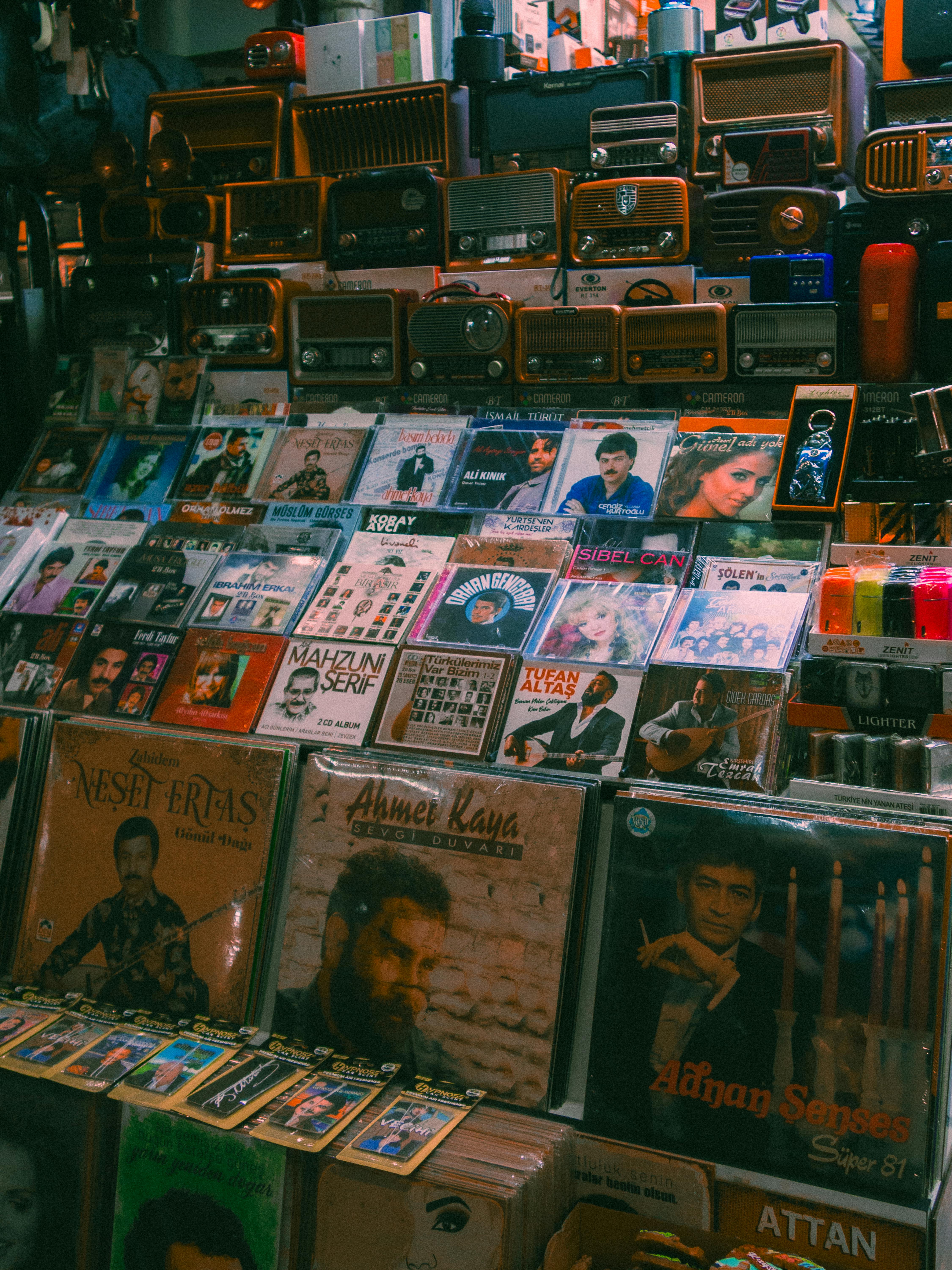 Uma imagem com vários discos de vinil e rádios